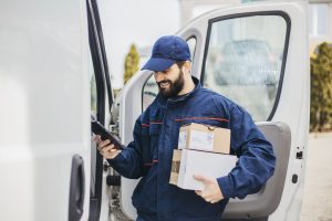 Delivery man with a parcel box in the car